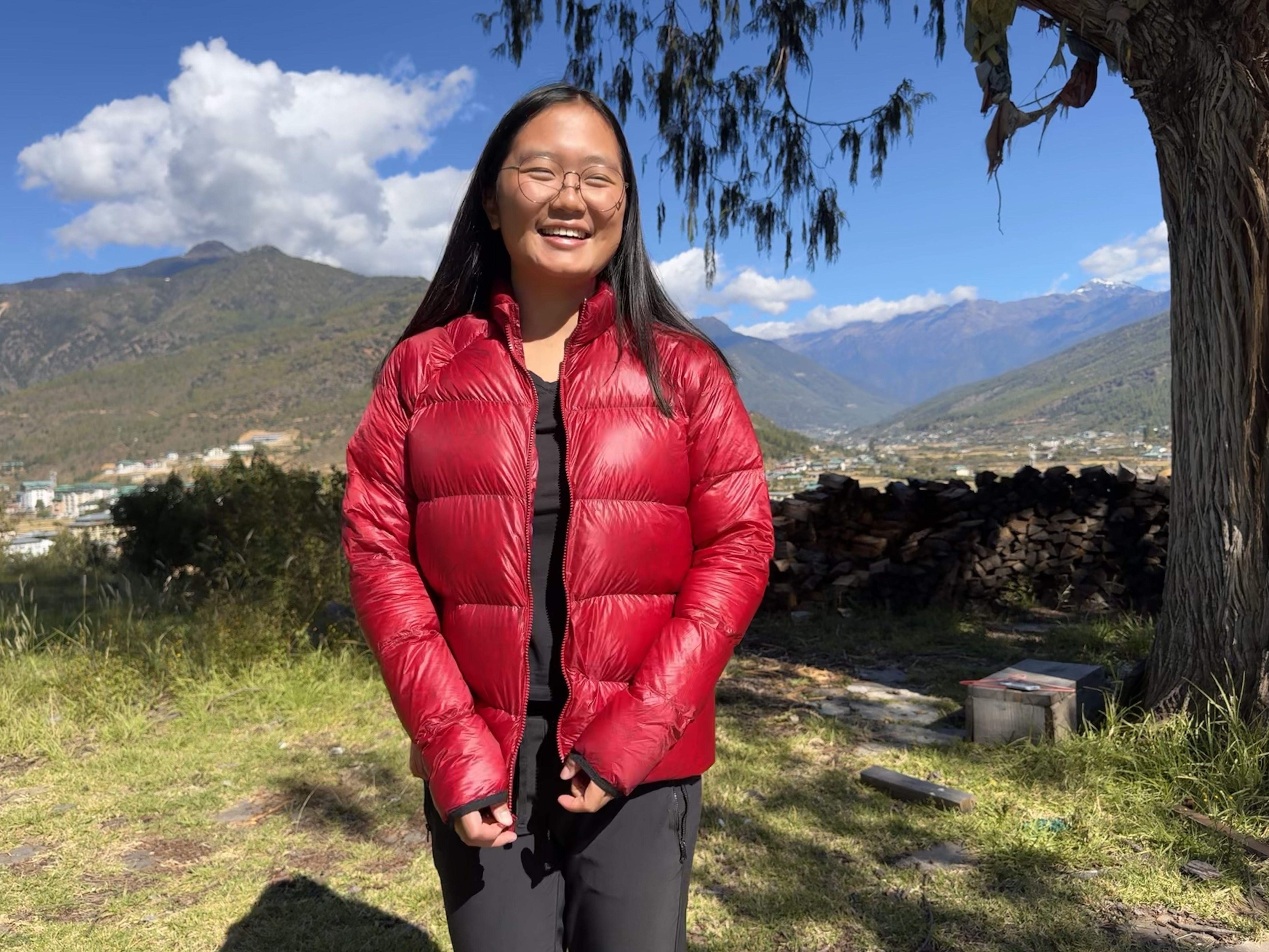 woman wearing a red puffy jacket and smiling
